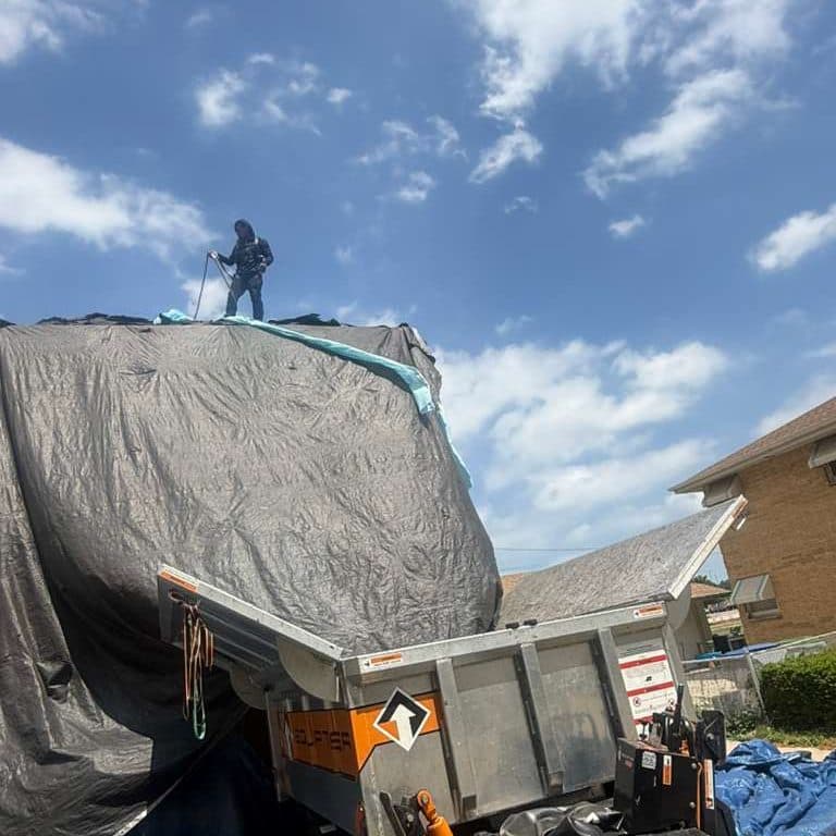 Roof tarped and the debris trailer loaded at the end of a tear-off day