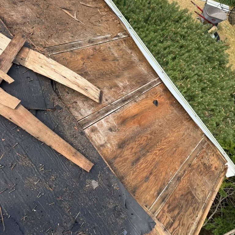 Tear-off in progress, exposing the original plank and plywood decking
